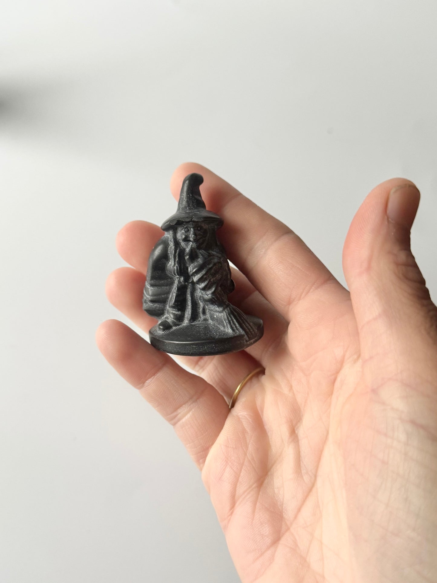 Witch with broom, black obsidian carving