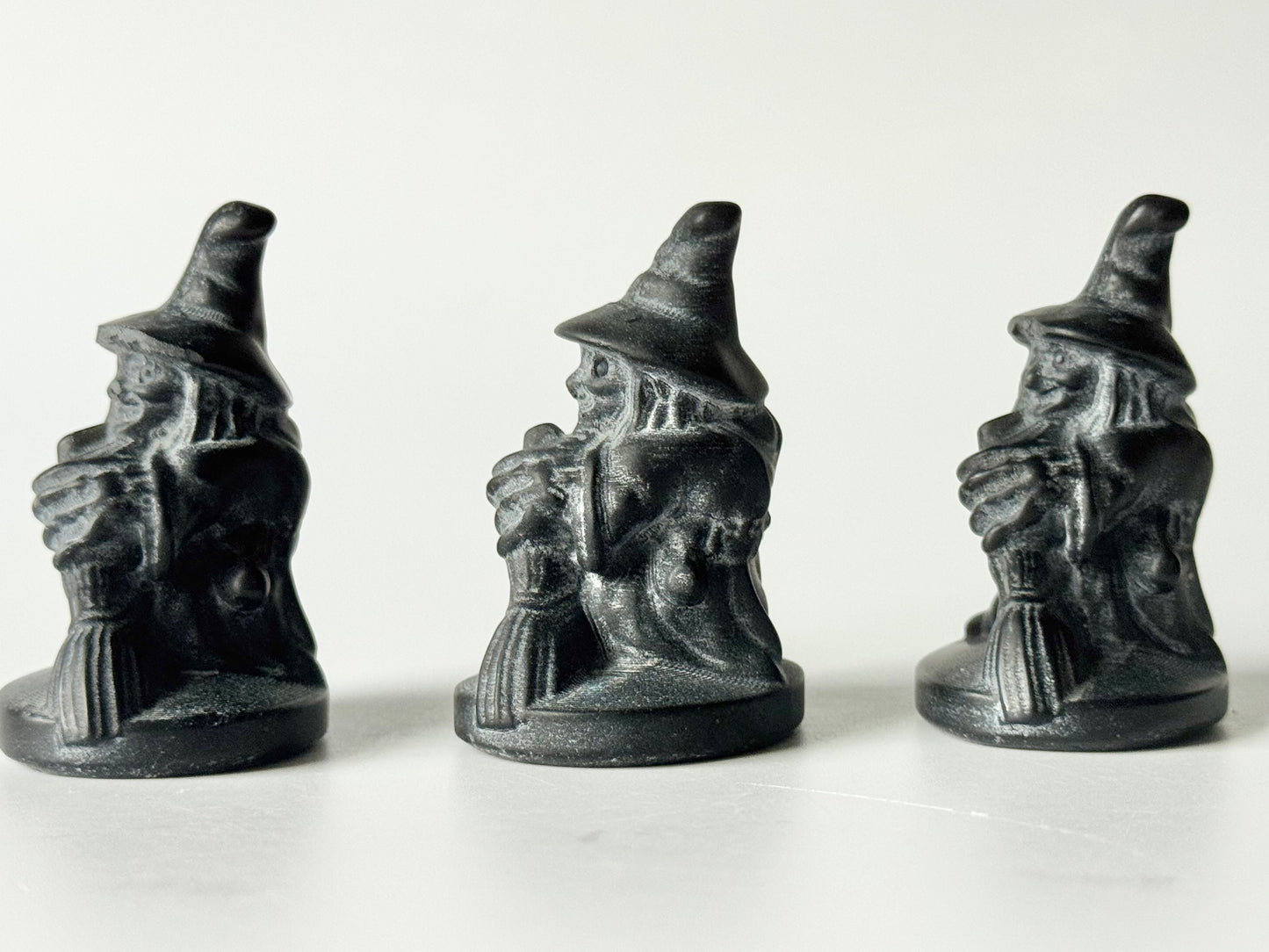 Witch with broom, black obsidian carving