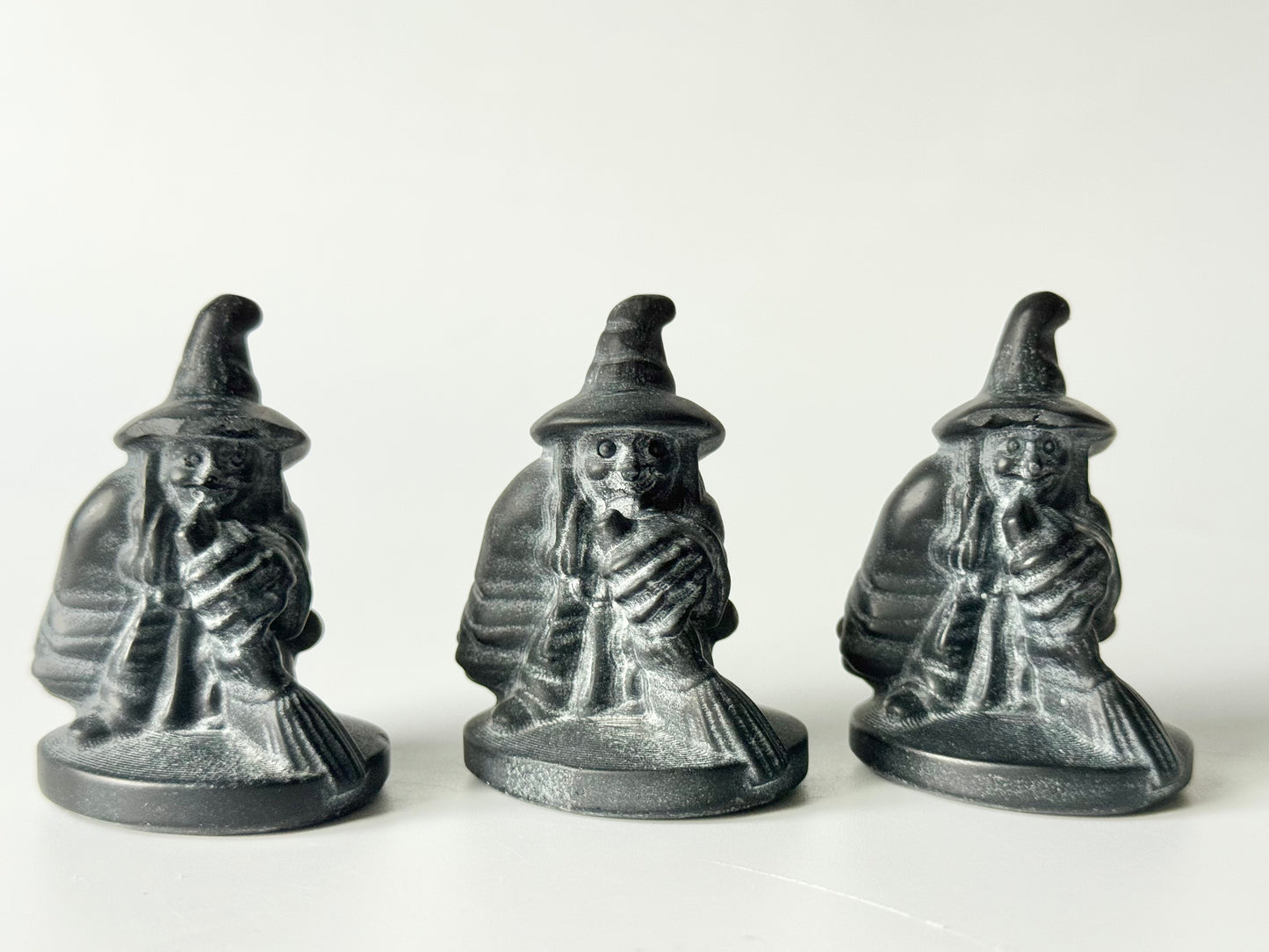 Witch with broom, black obsidian carving